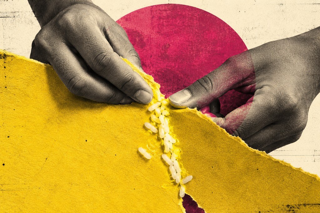 Hands pressing torn yellow paper together with cooked rice used as glue