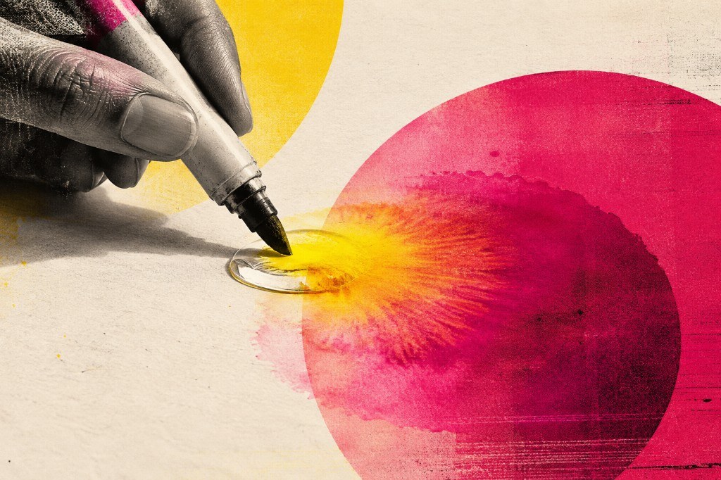 A hand dipping a marker tip into a water droplet as yellow and magenta ink blooms across the page